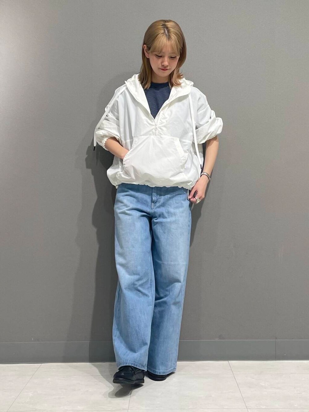 ブルー系のデニムパンツ、ホワイト系のパーカーを着用したレディースの春コーディネートの2枚目の写真