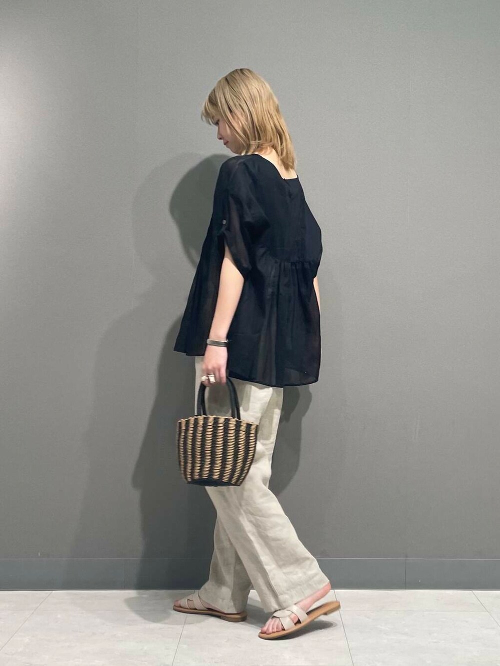 ベージュ系のその他パンツ、ブラック系のハンドバッグ、ブラック系のシャツ/ブラウスを着用したレディースの春コーディネートの6枚目の写真