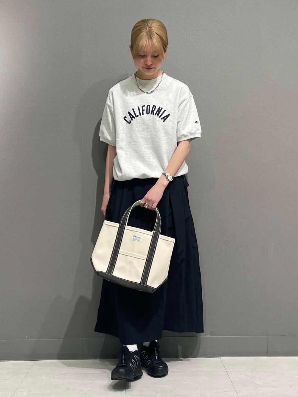 ブラック系のスカート、ホワイト系のヘアゴムを着用したレディースの春コーディネートの6枚目の写真