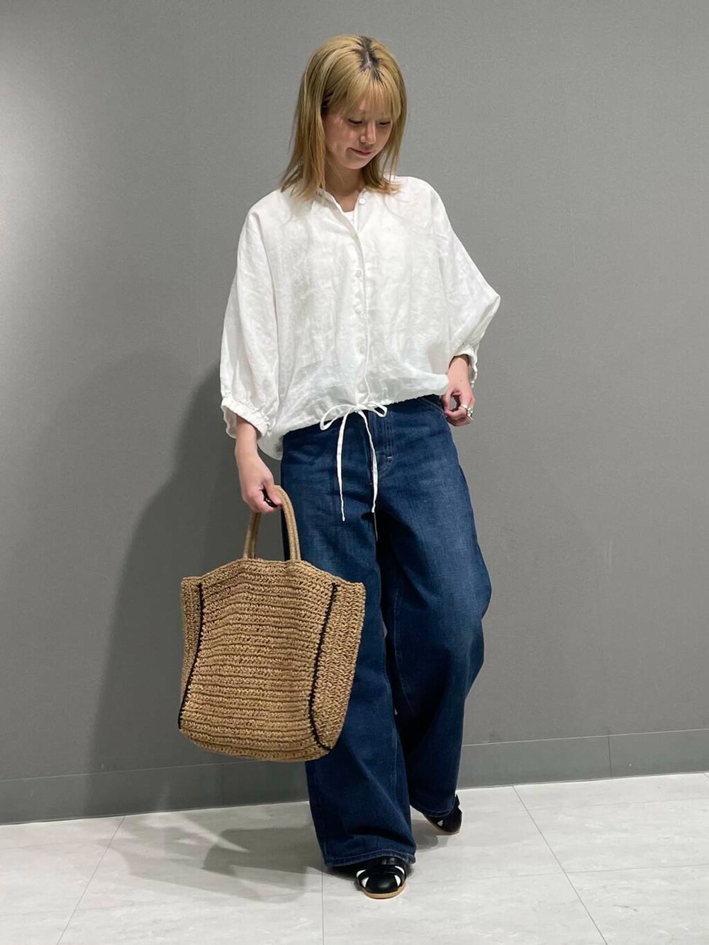 ブルー系のデニムパンツ、ホワイト系のシャツ/ブラウスを着用したレディースの春コーディネートの2枚目の写真