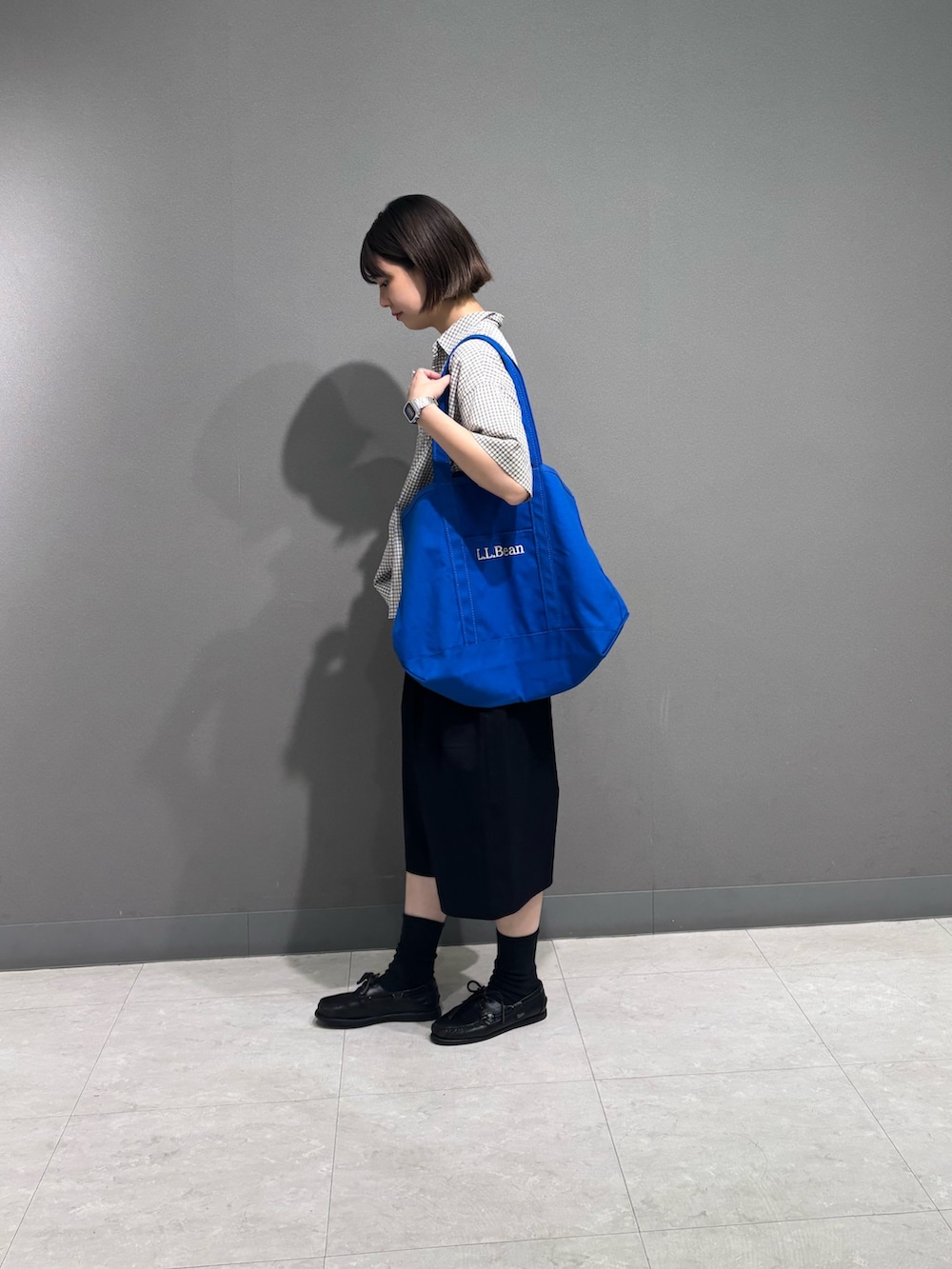 ホワイト系のシャツ/ブラウス、ブラック系のその他パンツ、ブルー系のトートバッグを着用したレディースの夏コーディネートの2枚目の写真