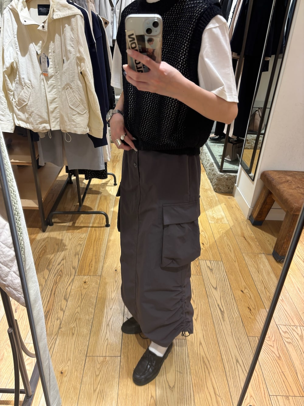 グレー系のTシャツ/カットソー、ブラック系のベスト、グレー系のスカートを着用したレディースの春コーディネートの6枚目の写真