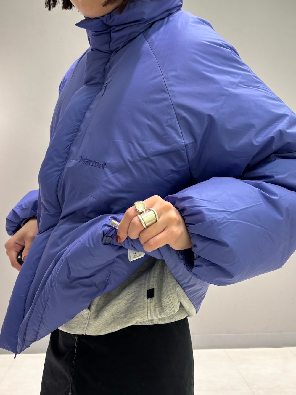 パープル系のダウンジャケット/コート、ブルー系のデニムパンツ、ベージュ系のサンダルを着用したレディースの秋コーディネートの4枚目の写真