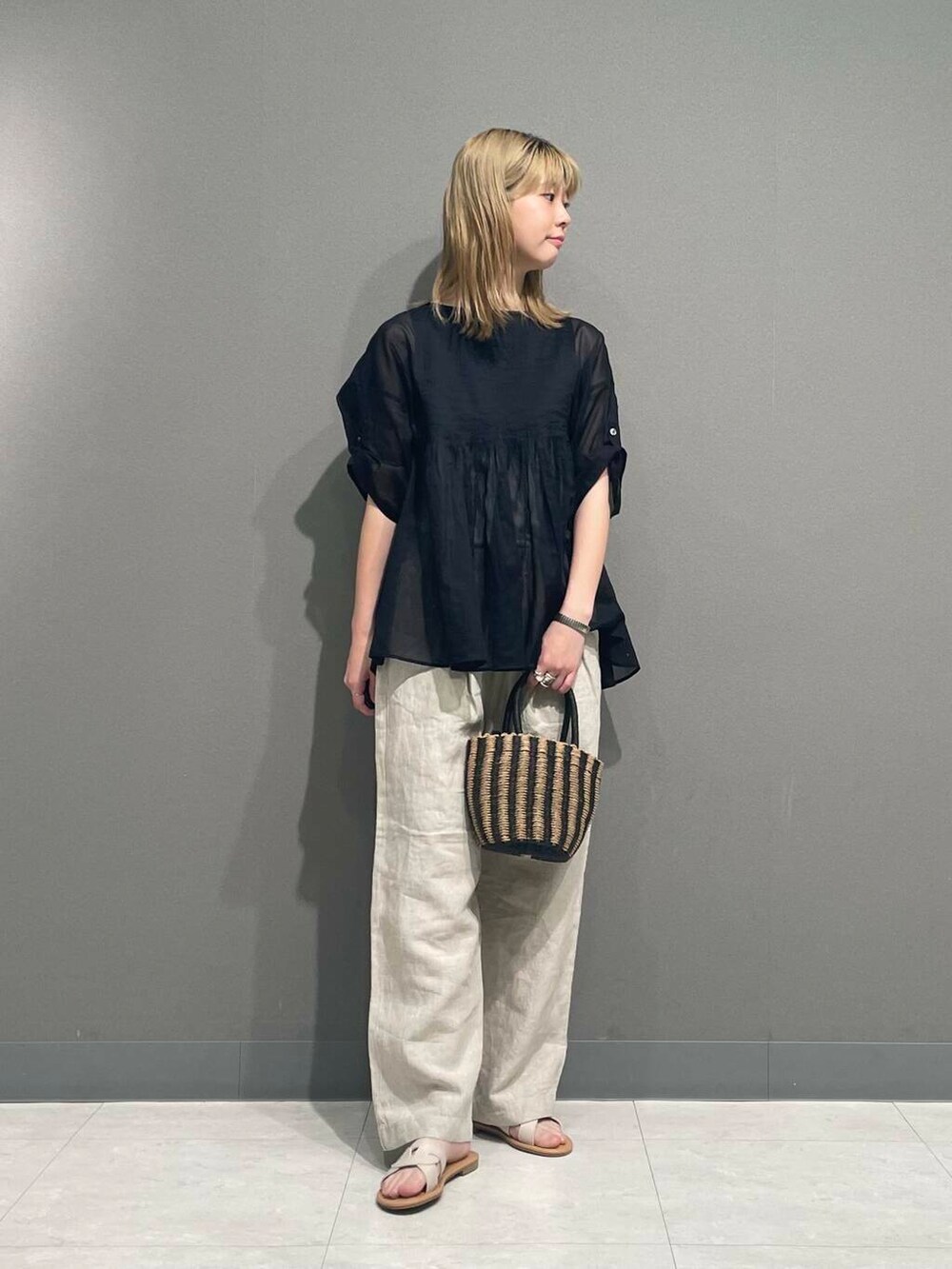 ベージュ系のその他パンツ、ブラック系のハンドバッグ、ブラック系のシャツ/ブラウスを着用したレディースの春コーディネートの3枚目の写真