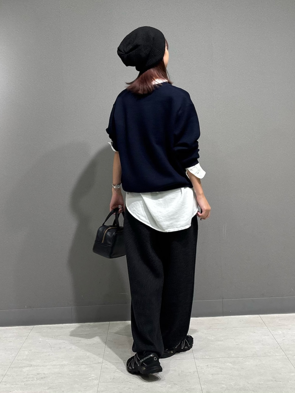 ブルー系のニット/セーター、ホワイト系のシャツ/ブラウス、グレー系のその他パンツを着用したレディースの秋コーディネートの3枚目の写真