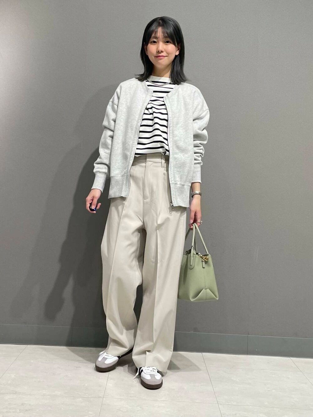 グレー系のカーディガン/ボレロ、グリーン系のショルダーバッグ、ブラック系のTシャツ/カットソーを着用したレディースの春コーディネートの5枚目の写真