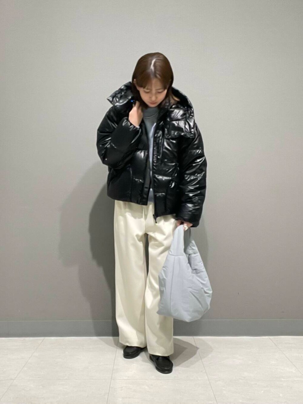 ホワイト系のその他パンツ、ブルー系のTシャツ/カットソー、ブラック系のダウンジャケット/コートを着用したレディースの冬コーディネートの2枚目の写真