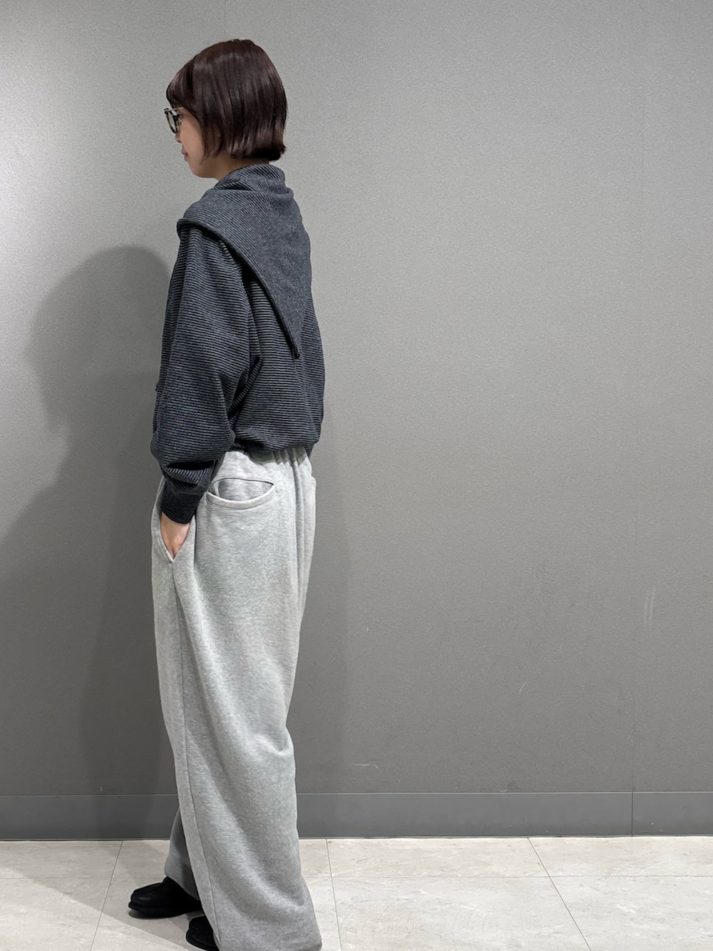 ブラック系のニット/セーター、グレー系のスウェットパンツを着用したレディースの秋コーディネートの5枚目の写真