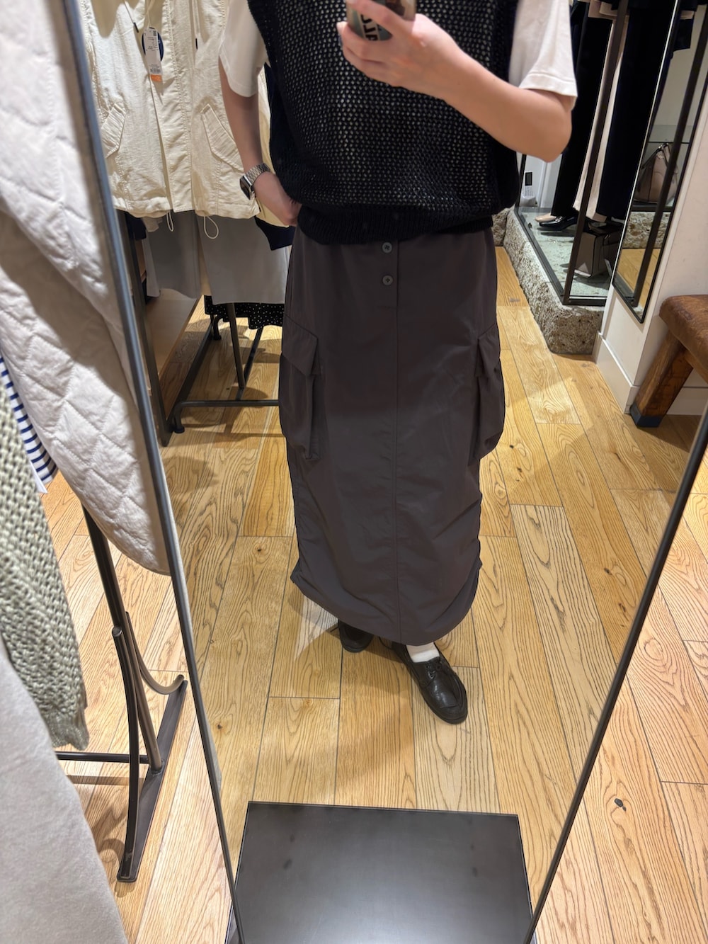 グレー系のTシャツ/カットソー、ブラック系のベスト、グレー系のスカートを着用したレディースの春コーディネートの5枚目の写真