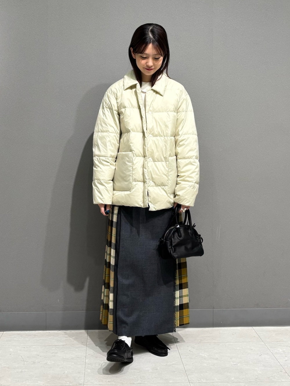 ホワイト系のダウンジャケット/コート、ホワイト系のニット/セーター、ベージュ系のスカートを着用したレディースの秋コーディネートの2枚目の写真