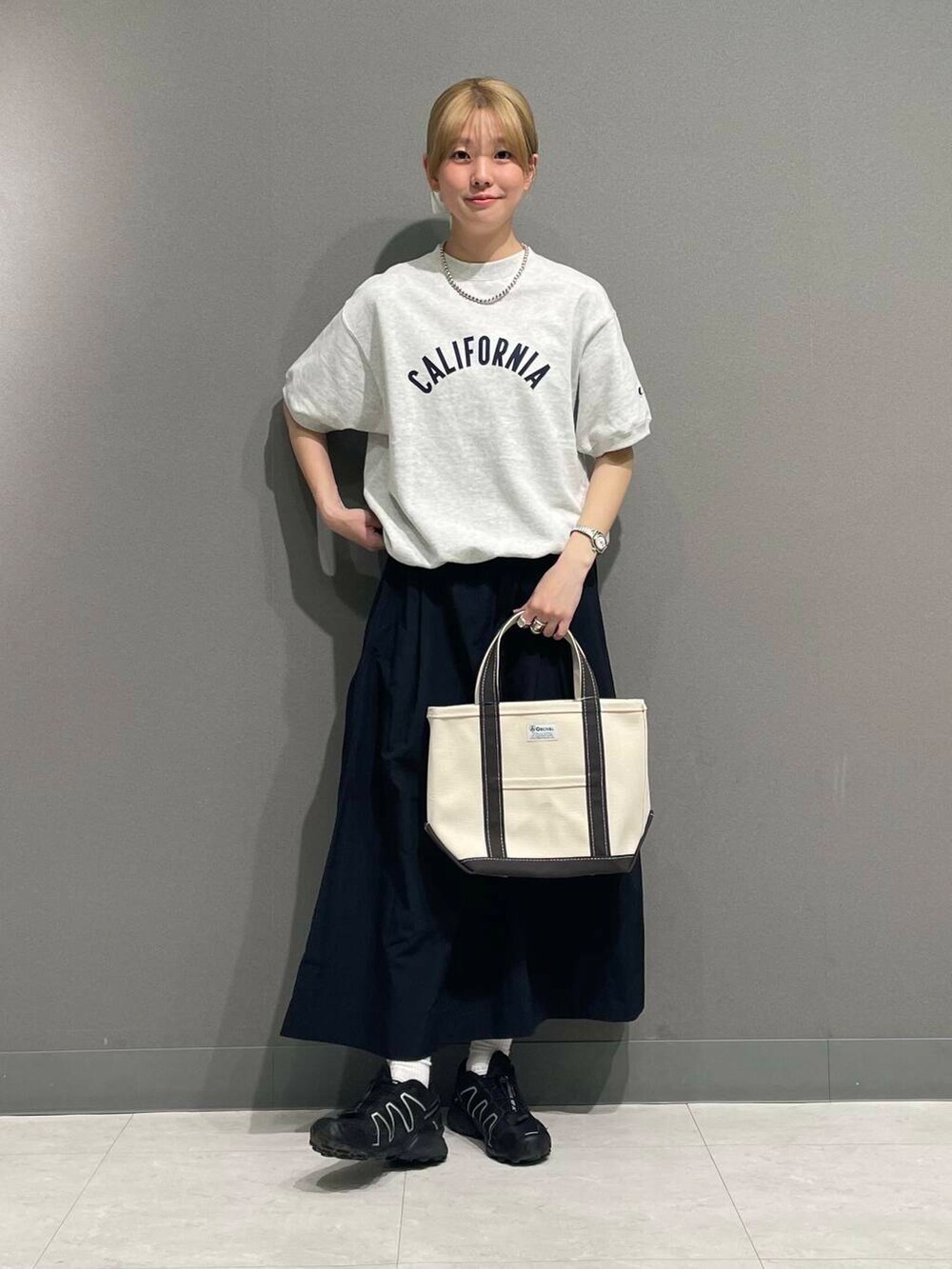 ブラック系のスカート、ホワイト系のヘアゴムを着用したレディースの春コーディネートの2枚目の写真