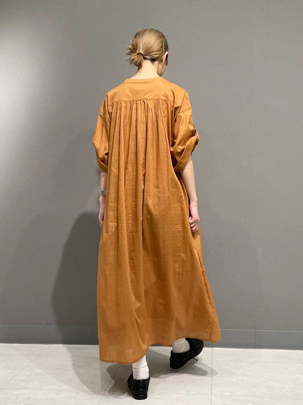 オレンジ系のワンピースを着用したレディースの春コーディネートの6枚目の写真