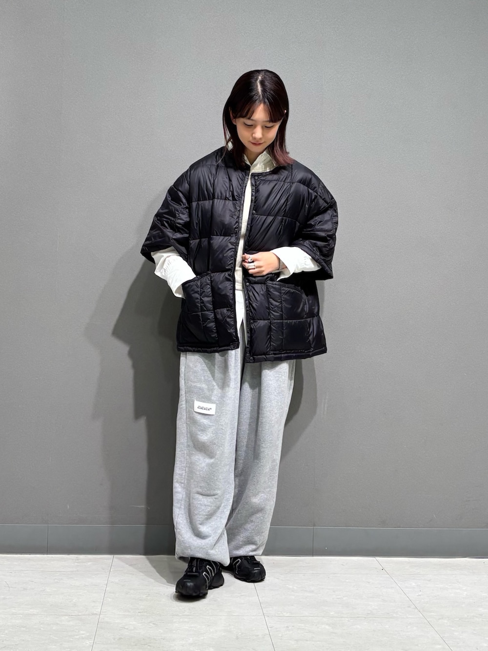 ブラック系のダウンジャケット/コート、グレー系のスウェットパンツを着用したレディースの秋コーディネートの3枚目の写真