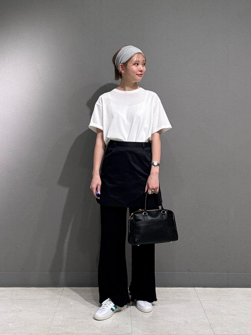 ブラック系のその他パンツ、ホワイト系のTシャツ/カットソー、ホワイト系のスニーカーを着用したレディースの春コーディネートの2枚目の写真
