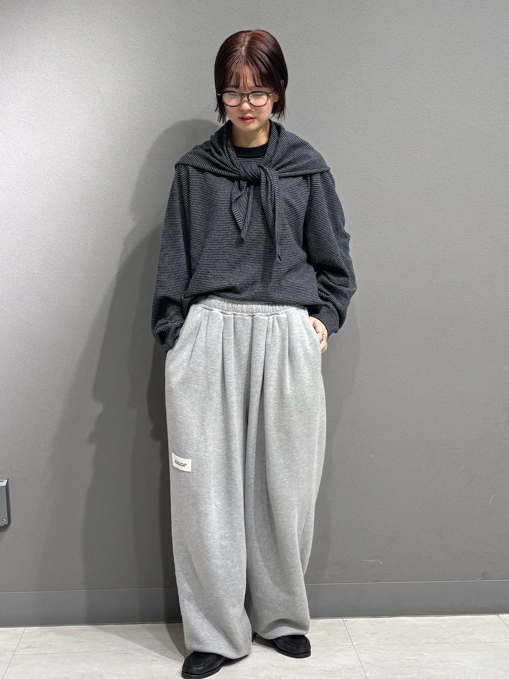 ブラック系のニット/セーター、グレー系のスウェットパンツを着用したレディースの秋コーディネートの2枚目の写真