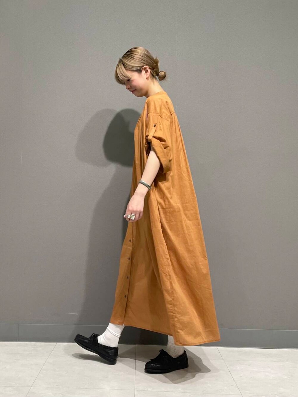 オレンジ系のワンピースを着用したレディースの春コーディネートの4枚目の写真