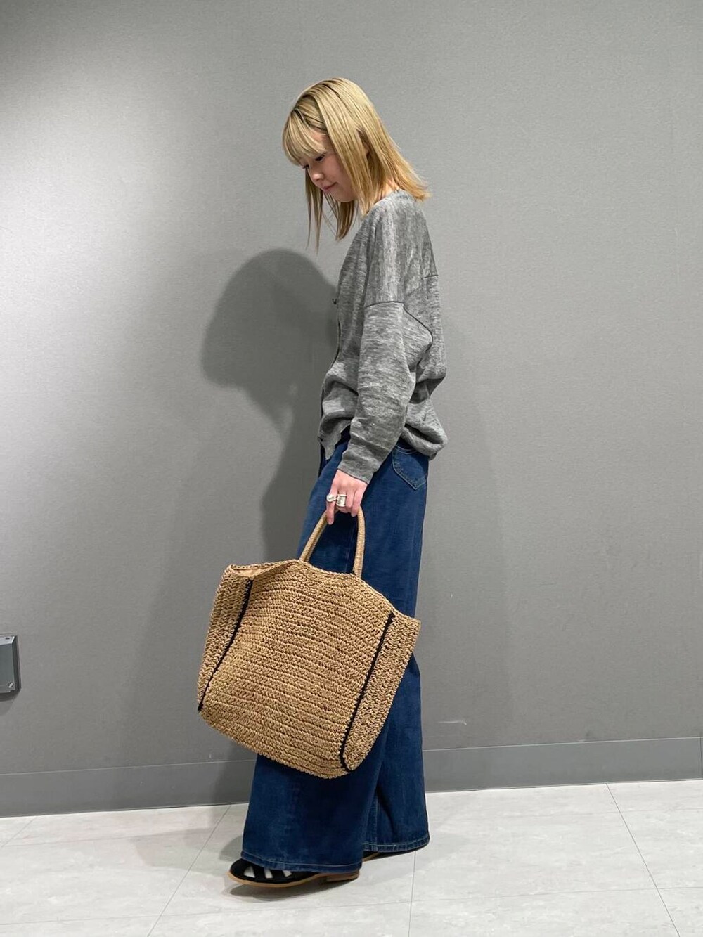 グレー系のカーディガン/ボレロ、ブラック系のサンダル、ベージュ系のトートバッグを着用したレディースの春コーディネートの3枚目の写真