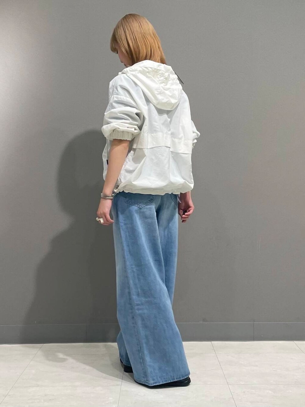 ブルー系のデニムパンツ、ホワイト系のパーカーを着用したレディースの春コーディネートの5枚目の写真