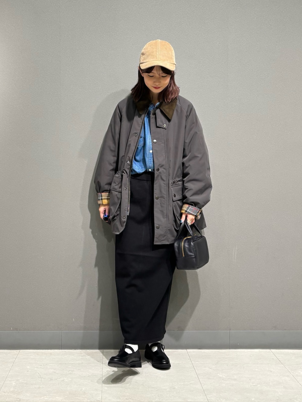 グレー系のその他アウター、ブラック系のローファー、ブラック系のスカートを着用したレディースの秋コーディネートの3枚目の写真
