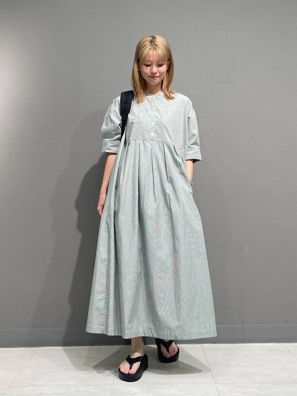 ブラック系のサンダル、グリーン系のワンピースを着用したレディースの夏コーディネートの2枚目の写真