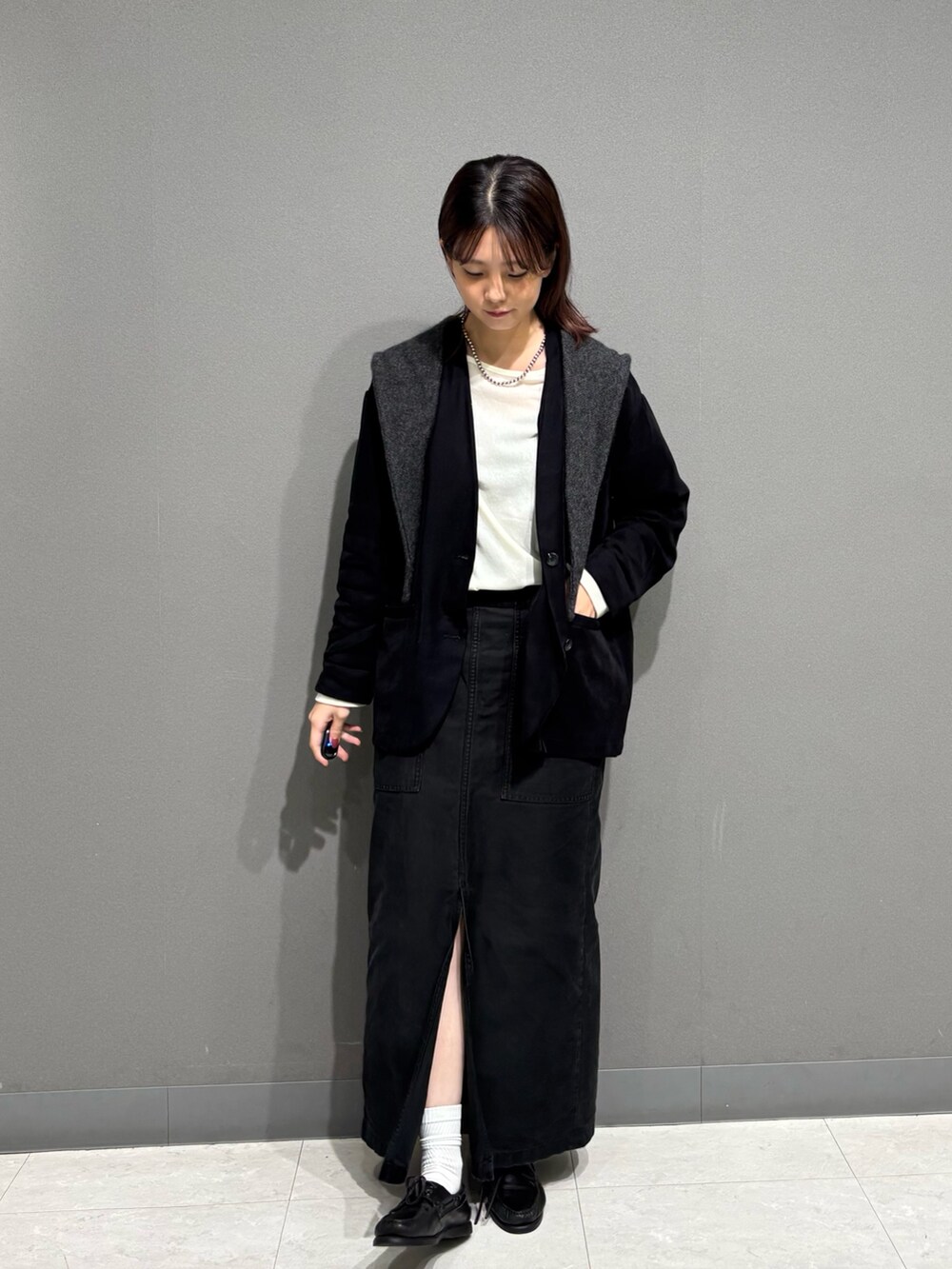 ブラック系のノーカラージャケット、グレー系のマフラーを着用したレディースの秋コーディネートの5枚目の写真