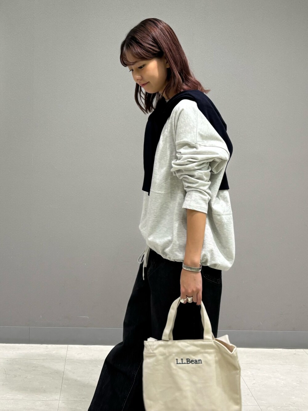 ベージュ系のTシャツ/カットソー、ブルー系のカーディガン/ボレロ、ブラック系のデニムパンツを着用したレディースの秋コーディネートの7枚目の写真