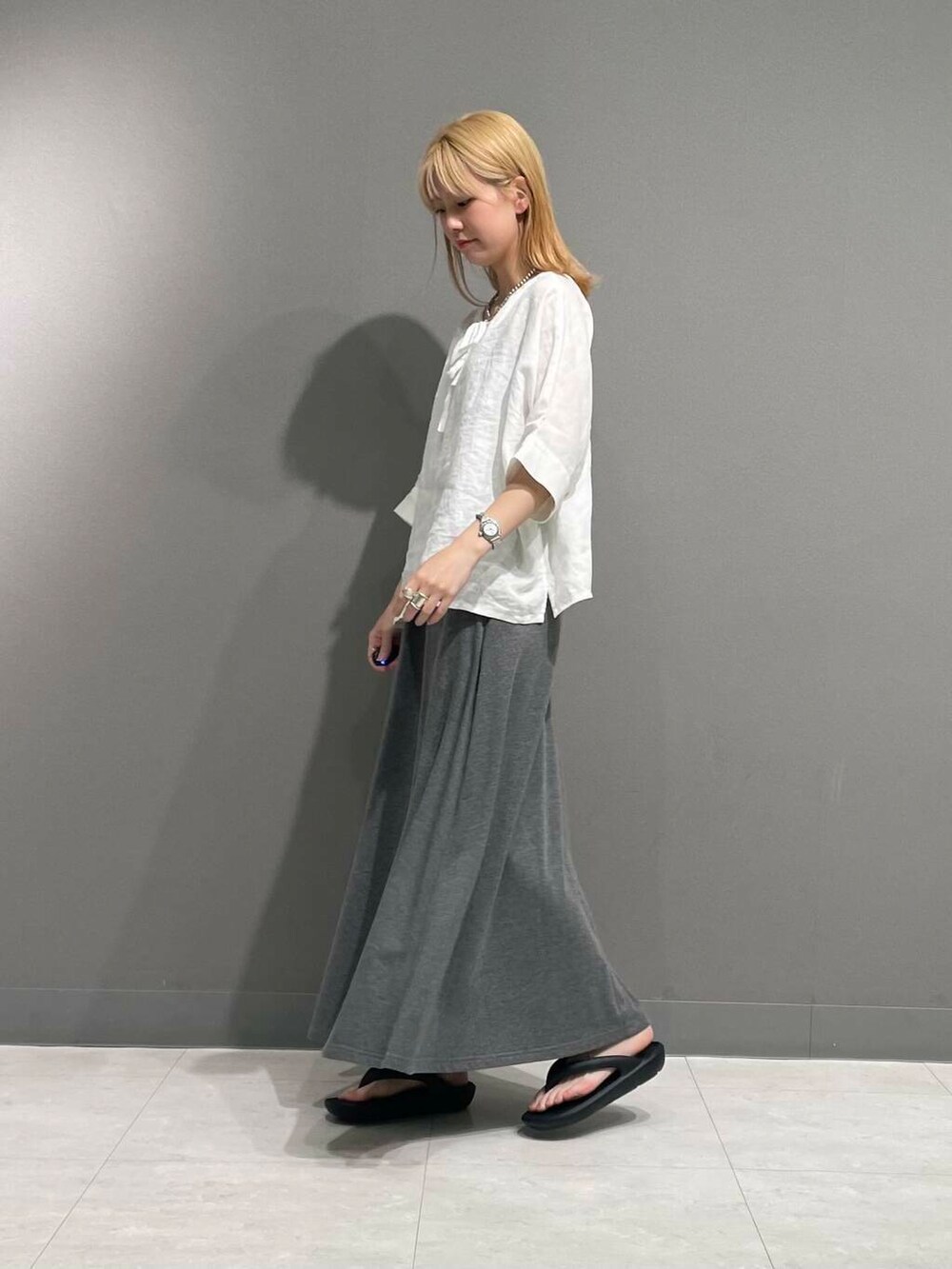 グレー系のスカート、ホワイト系のシャツ/ブラウスを着用したレディースの春コーディネートの3枚目の写真