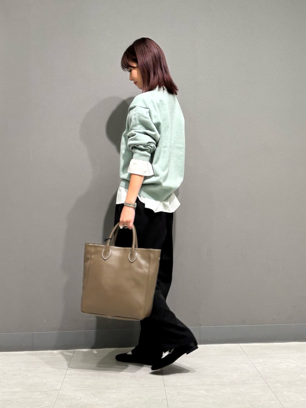 ホワイト系のシャツ/ブラウス、グリーン系のニット/セーター、グレー系のトートバッグを着用したレディースの秋コーディネートの4枚目の写真