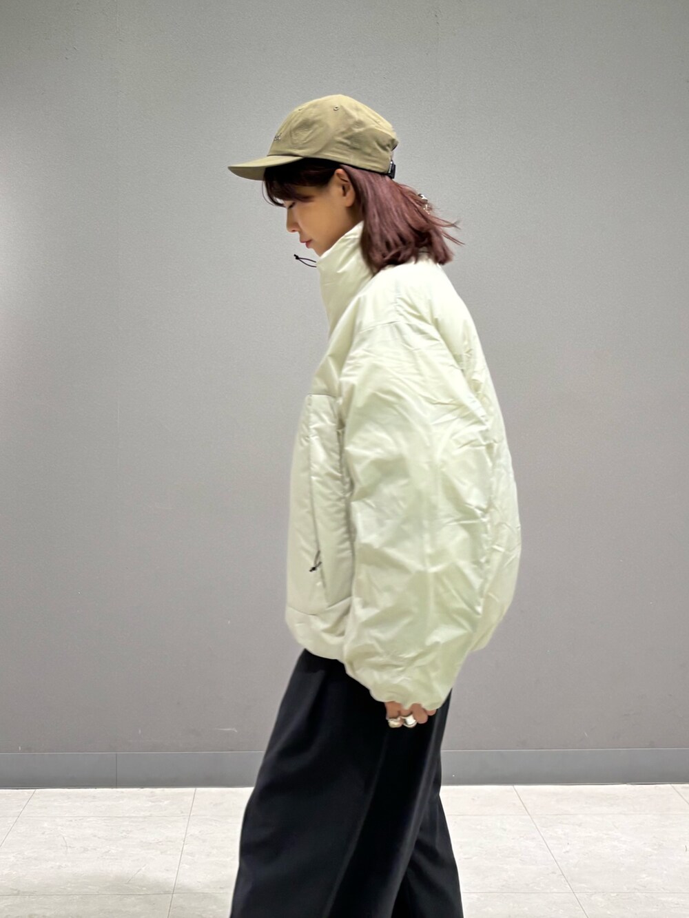 ホワイト系のダウンジャケット/コート、グリーン系のキャップを着用したレディースの秋コーディネートの3枚目の写真