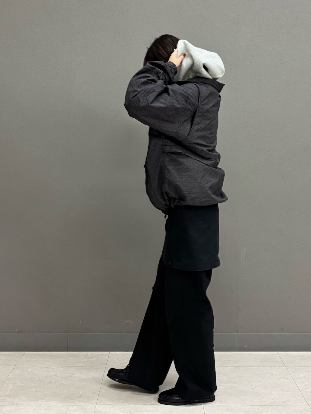 グレー系のパーカー、ブラック系のジャケット/アウターを着用したレディースの冬コーディネートの2枚目の写真