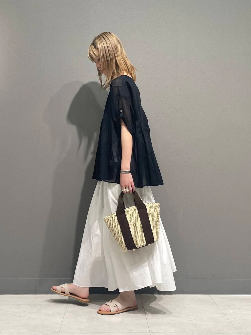 ホワイト系のサンダル、ブラック系のシャツ/ブラウスを着用したレディースの春コーディネートの3枚目の写真