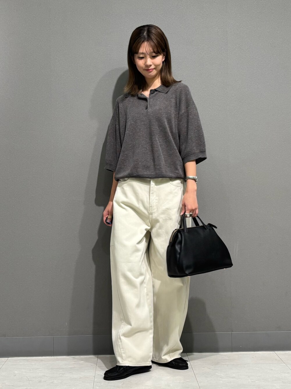グレー系のポロシャツ、ホワイト系のその他パンツ、ブラック系のトートバッグを着用したレディースの秋コーディネートの5枚目の写真