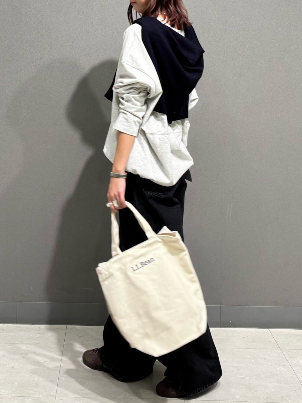 ベージュ系のTシャツ/カットソー、ブルー系のカーディガン/ボレロ、ブラック系のデニムパンツを着用したレディースの秋コーディネートの5枚目の写真