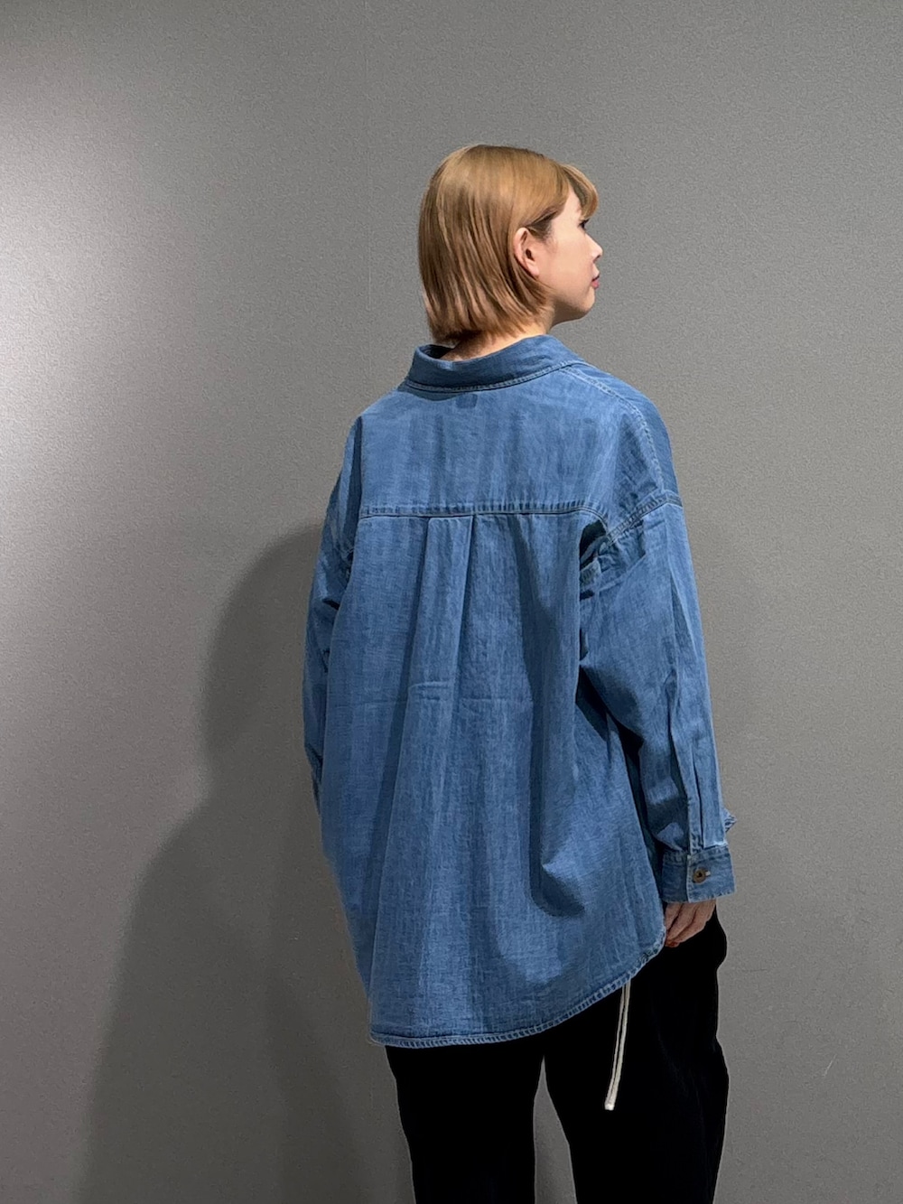 シルバー系のスニーカー、ブルー系のシャツ/ブラウス、ホワイト系のTシャツ/カットソーを着用したレディースの冬コーディネートの4枚目の写真