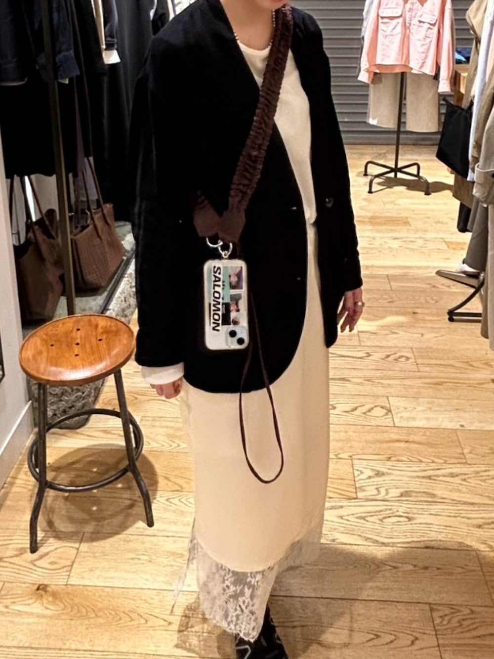 ホワイト系のスカート、ブラック系のノーカラージャケット、ブラウン系のバッグを着用したレディースの冬コーディネートの3枚目の写真