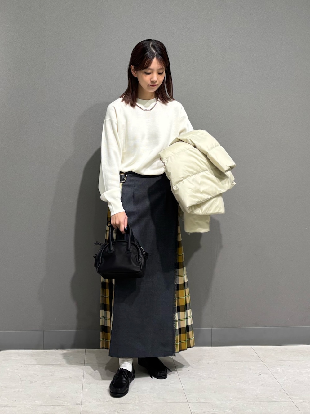 ホワイト系のダウンジャケット/コート、ホワイト系のニット/セーター、ベージュ系のスカートを着用したレディースの秋コーディネートの8枚目の写真