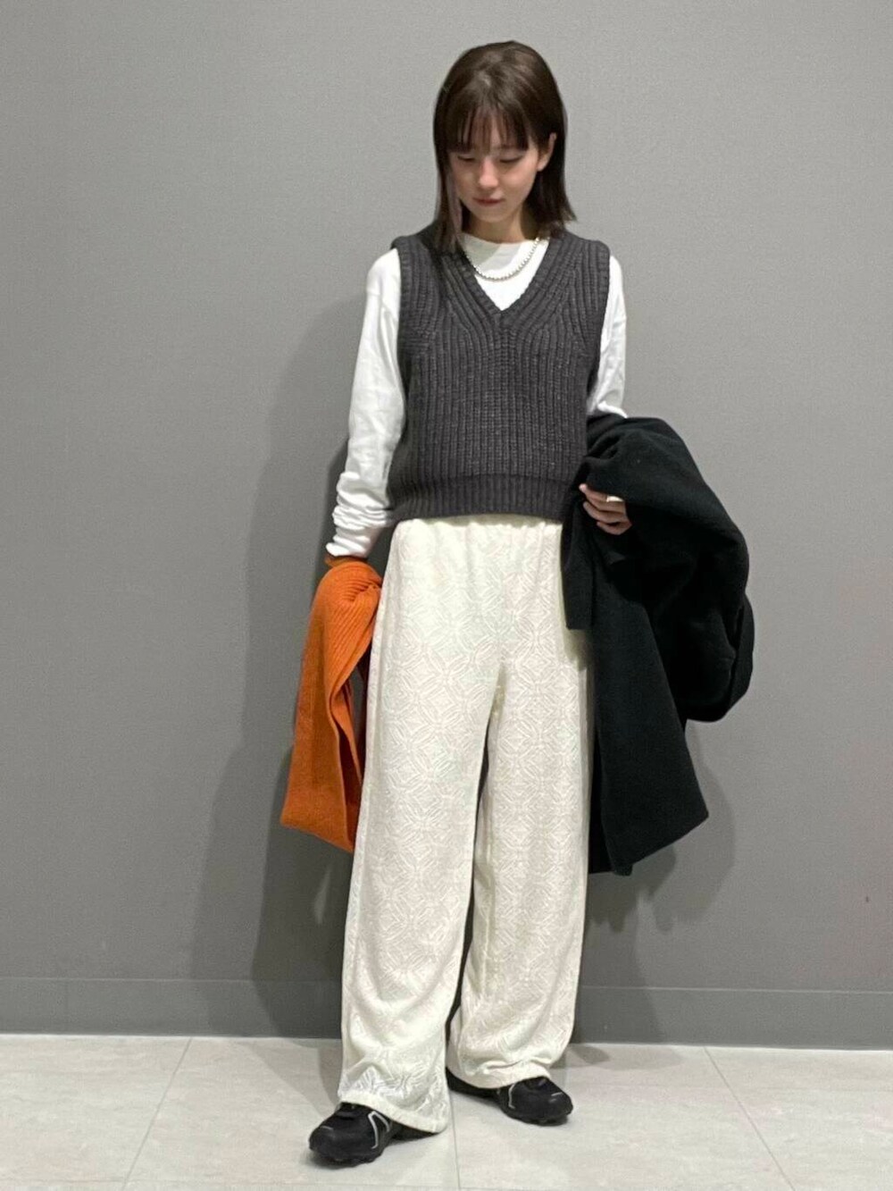 グレー系のその他アウター、グレー系のベスト、ホワイト系のその他パンツを着用したレディースの冬コーディネートの4枚目の写真
