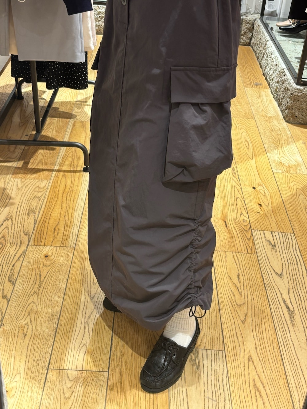 グレー系のTシャツ/カットソー、ブラック系のベスト、グレー系のスカートを着用したレディースの春コーディネートの3枚目の写真