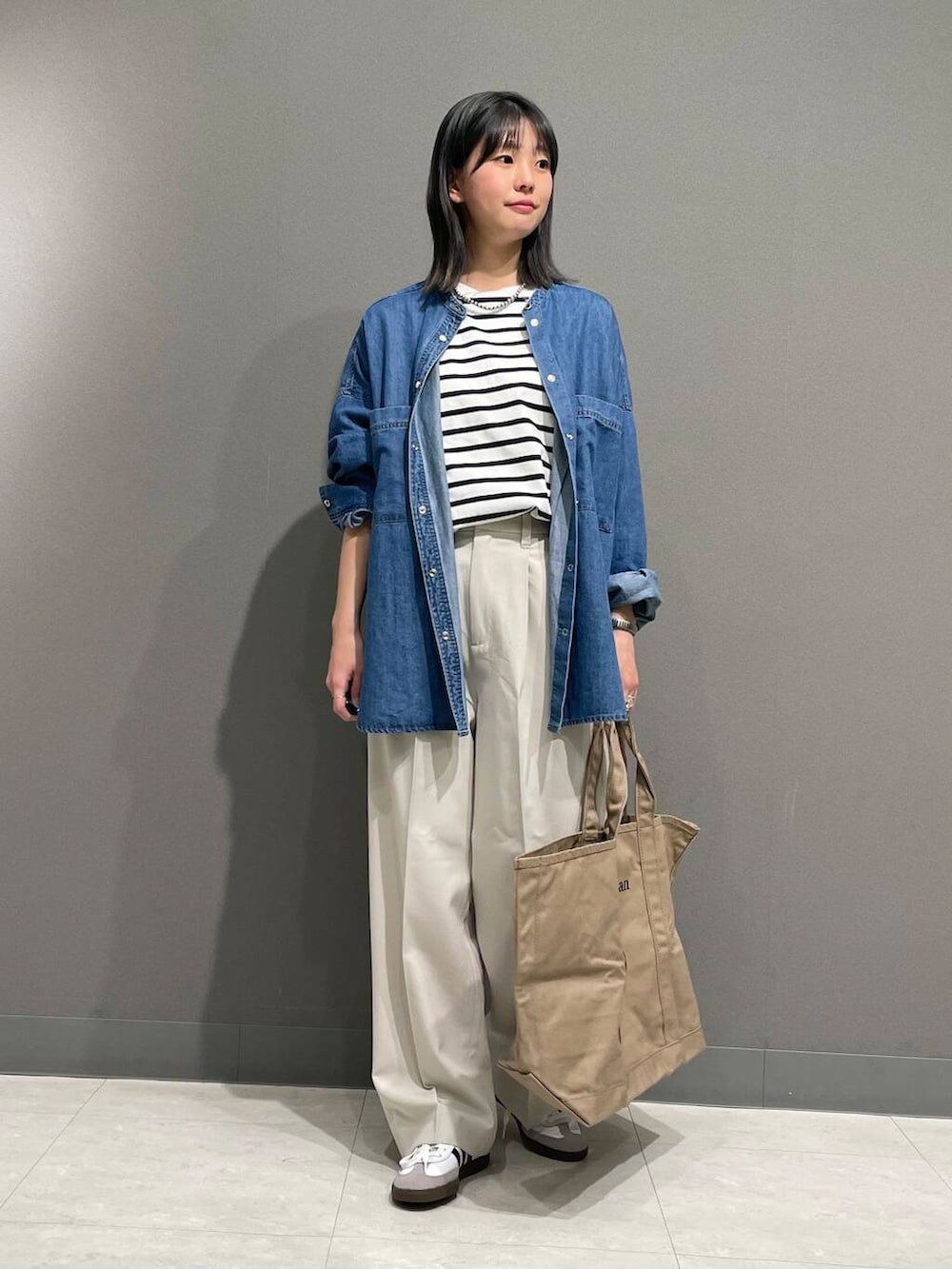 ブルー系のシャツ/ブラウス、ホワイト系のスニーカー、ブラック系のTシャツ/カットソーを着用したレディースの春コーディネートの5枚目の写真