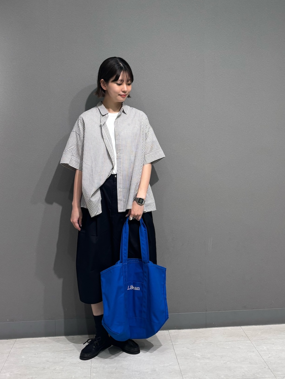 ホワイト系のシャツ/ブラウス、ブラック系のその他パンツ、ブルー系のトートバッグを着用したレディースの夏コーディネートの3枚目の写真