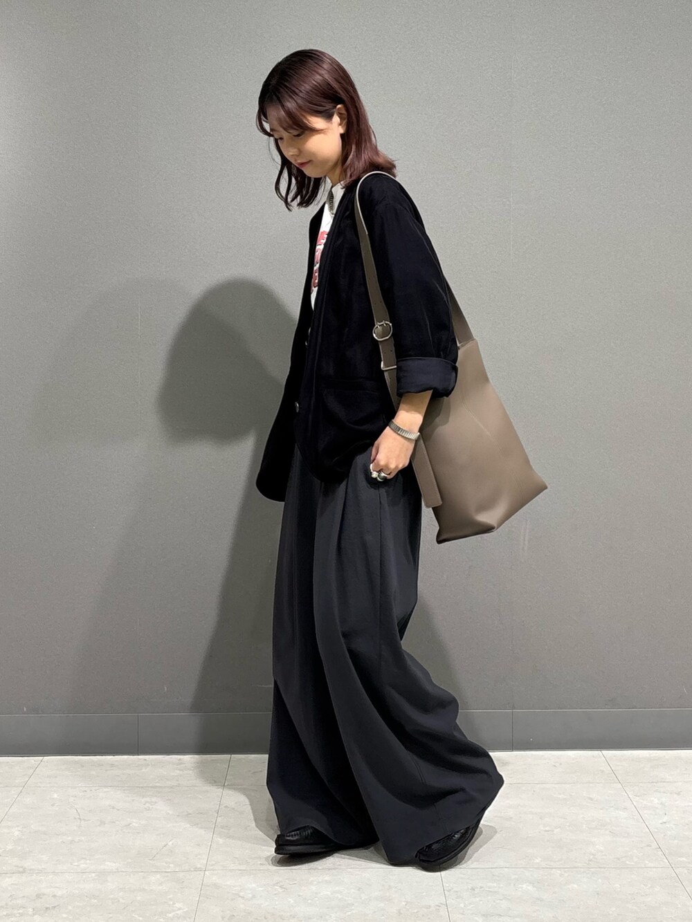 ブラック系のノーカラージャケット、グレー系のショルダーバッグを着用したレディースの秋コーディネートの3枚目の写真