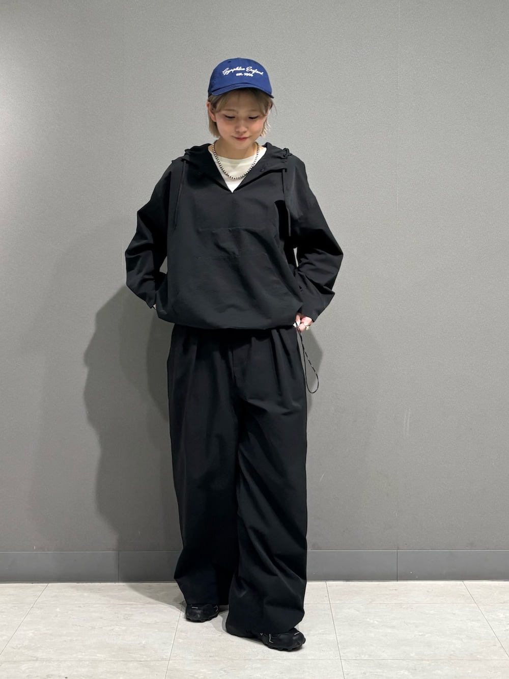 ブラック系のその他アウター、ブラック系のその他パンツ、ブルー系のキャップを着用したレディースの春コーディネートの3枚目の写真