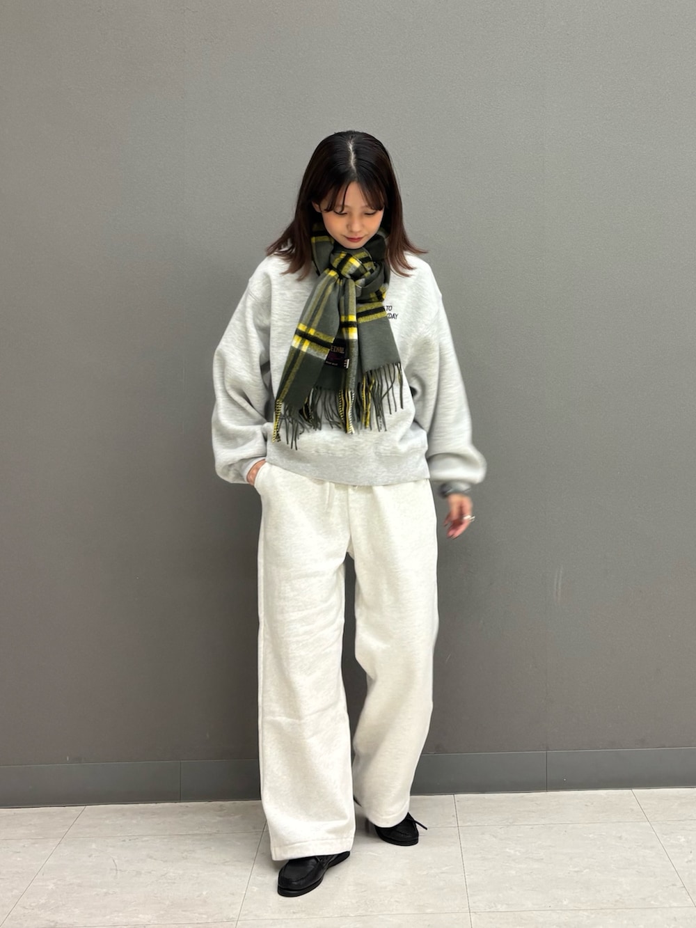 ベージュ系のその他パンツ、グレー系のニット/セーター、ブルー系のダウンジャケット/コートを着用したレディースの秋コーディネートの3枚目の写真