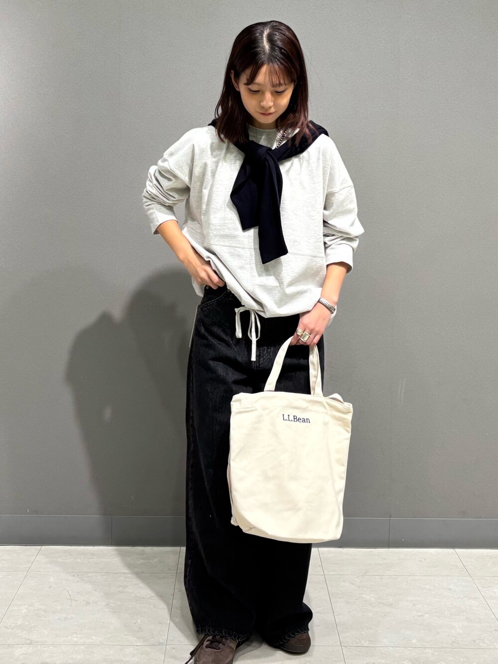 ベージュ系のTシャツ/カットソー、ブルー系のカーディガン/ボレロ、ブラック系のデニムパンツを着用したレディースの秋コーディネートの6枚目の写真