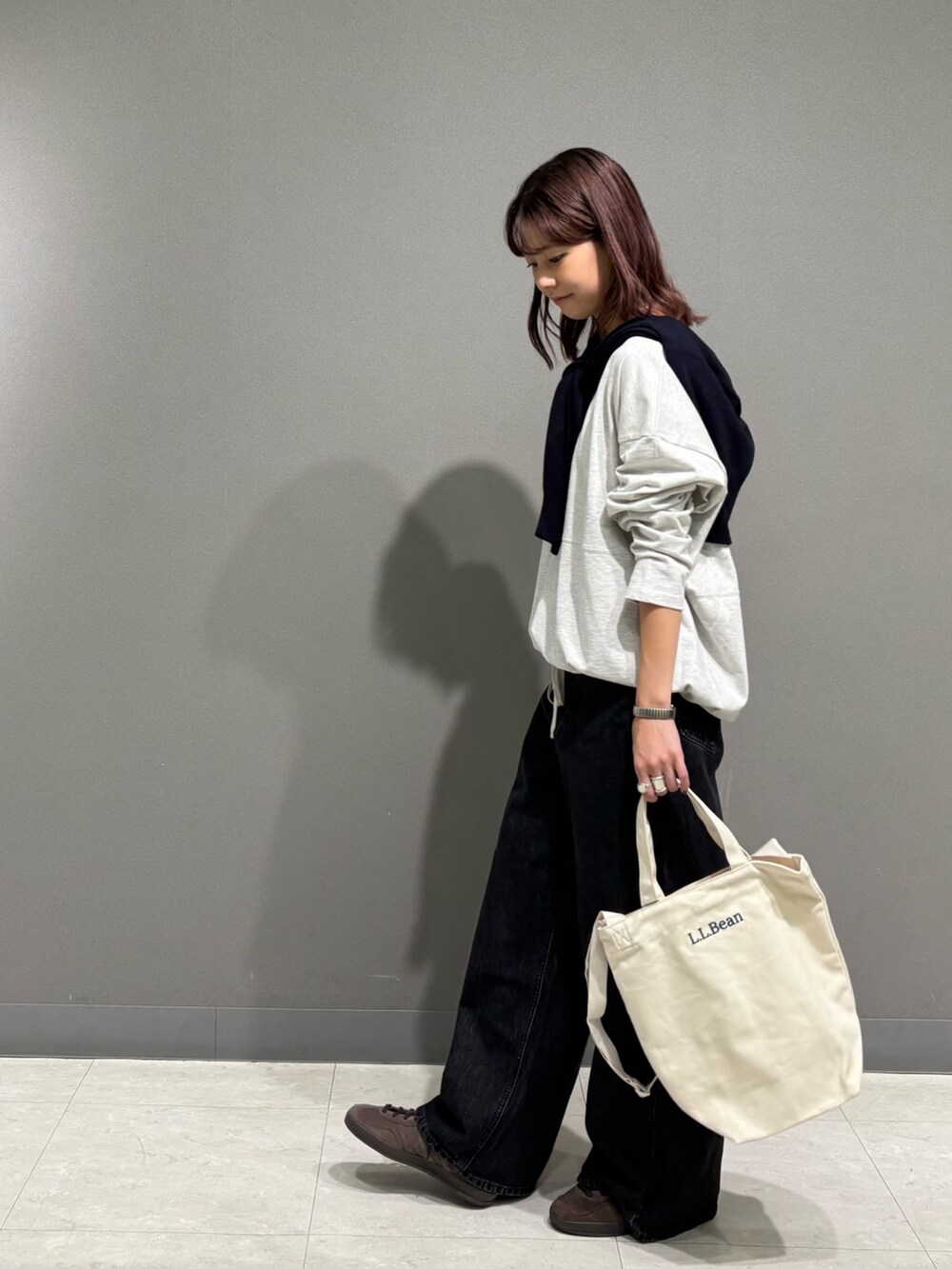 ベージュ系のTシャツ/カットソー、ブルー系のカーディガン/ボレロ、ブラック系のデニムパンツを着用したレディースの秋コーディネートの4枚目の写真