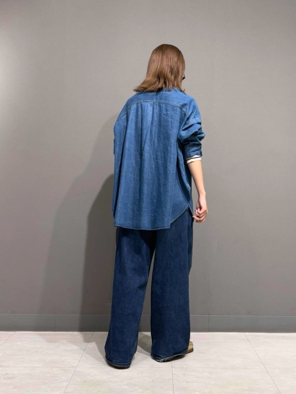 ブルー系のシャツ/ブラウス、ブラック系のTシャツ/カットソー、ブラック系のハンドバッグを着用したレディースの秋コーディネートの3枚目の写真