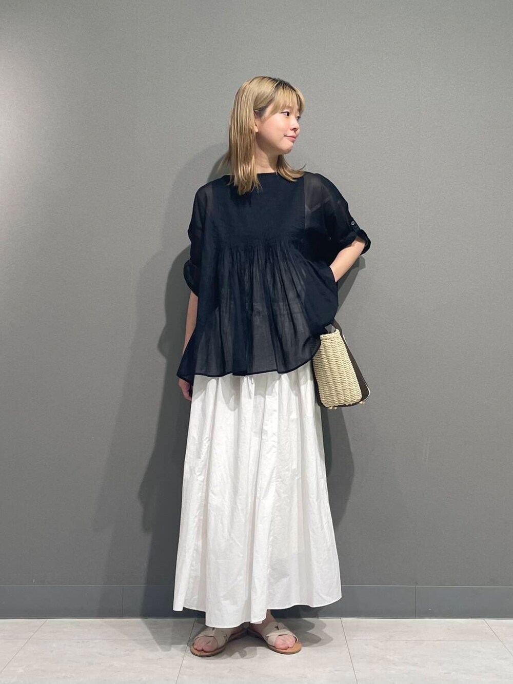 ホワイト系のサンダル、ブラック系のシャツ/ブラウスを着用したレディースの春コーディネートの6枚目の写真