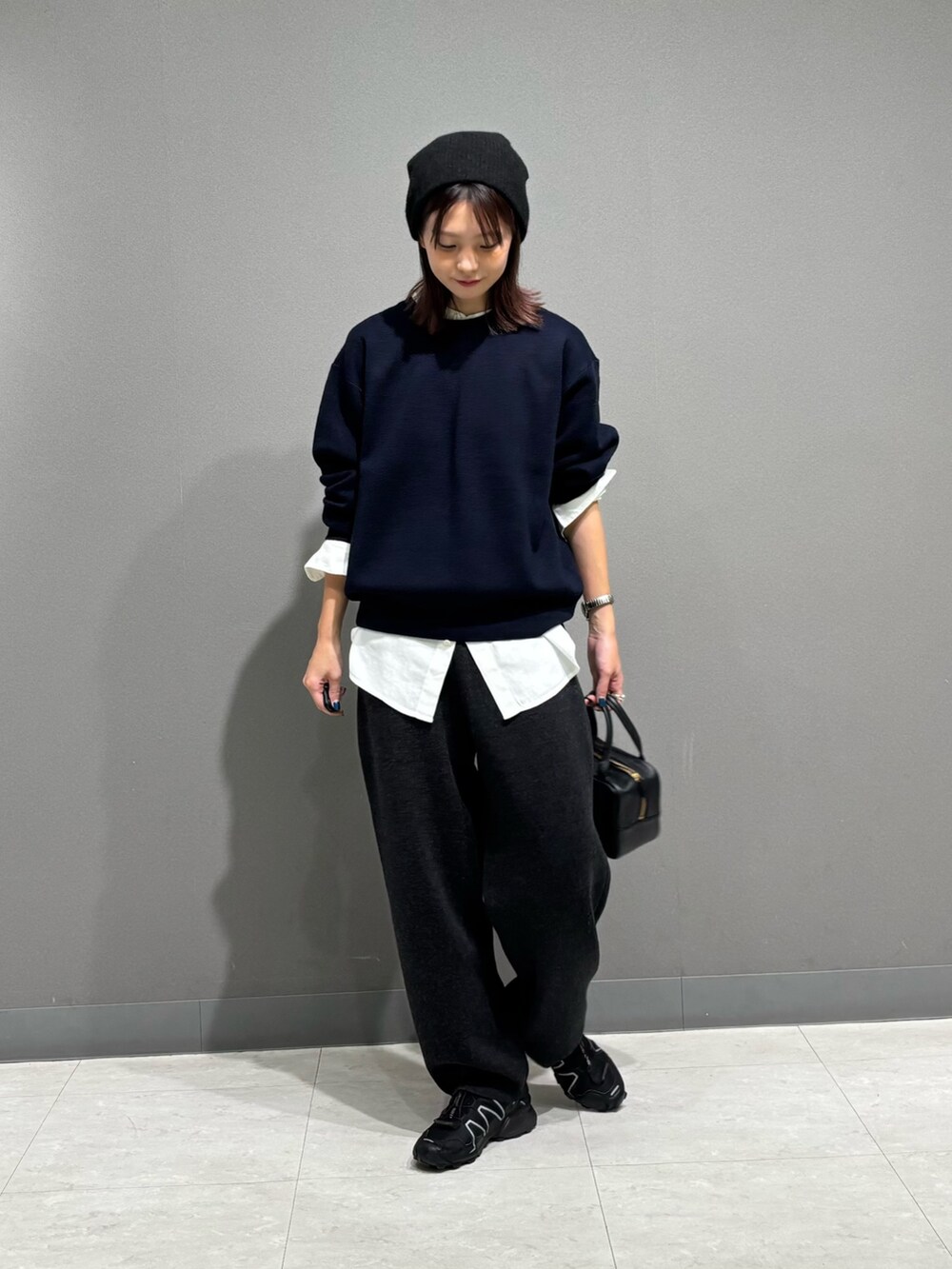 ブルー系のニット/セーター、ホワイト系のシャツ/ブラウス、グレー系のその他パンツを着用したレディースの秋コーディネートの2枚目の写真