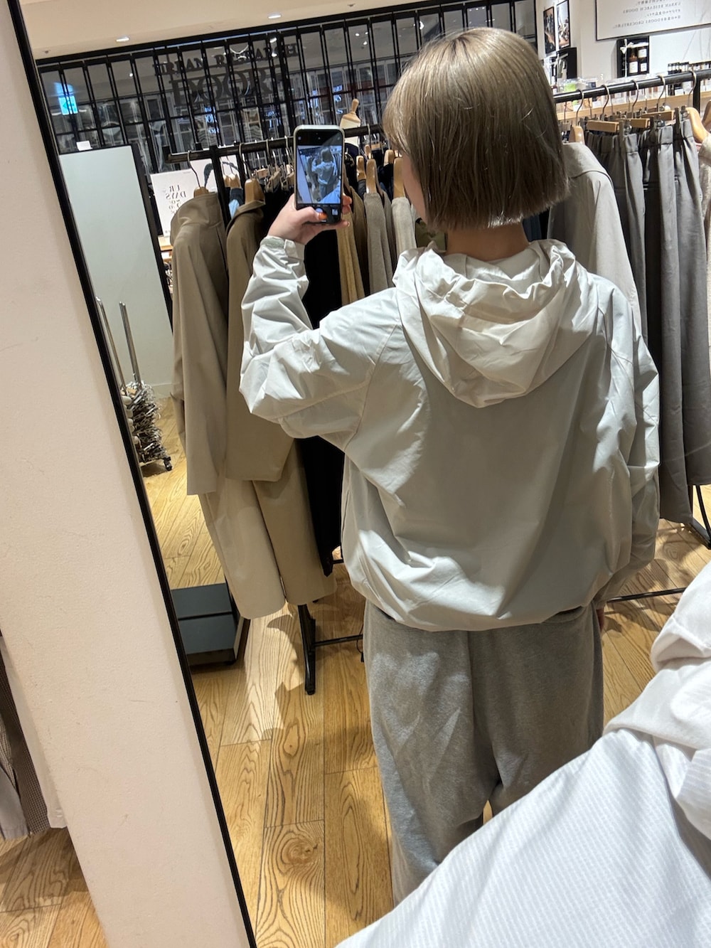 ホワイト系のテーラードジャケット、グレー系のスウェットパンツを着用したレディースの冬コーディネートの4枚目の写真