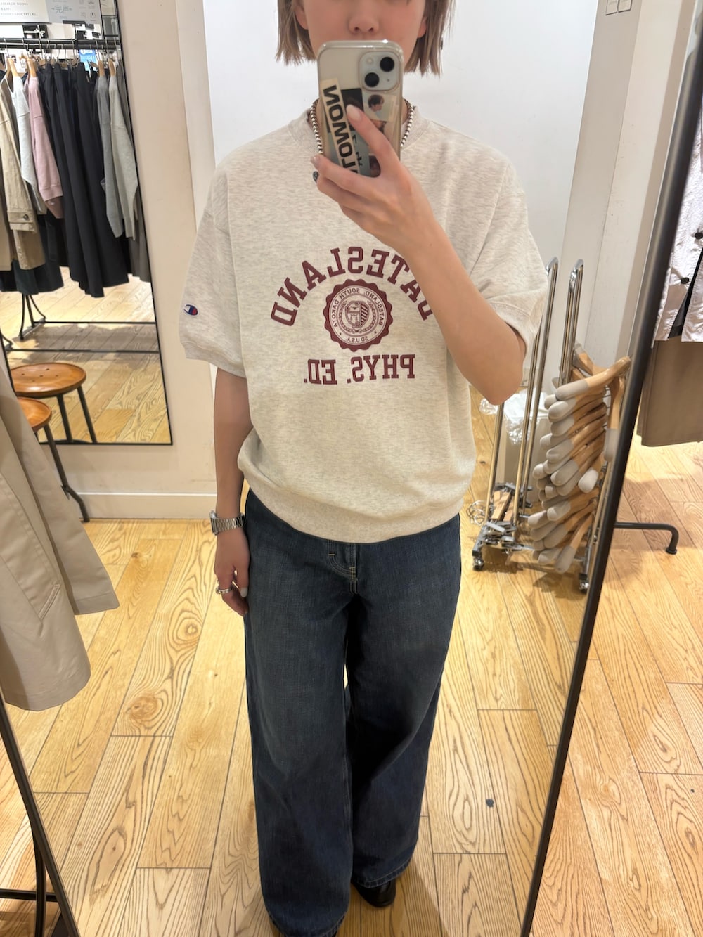 ベージュ系のスウェット、ブルー系のデニムパンツを着用したレディースの春コーディネートの3枚目の写真